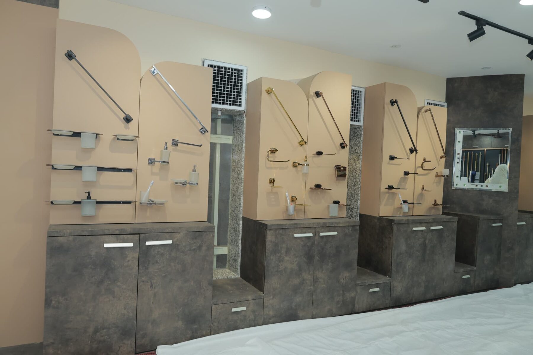 Bath accessories in gold, black and chrome finishes on beige panels